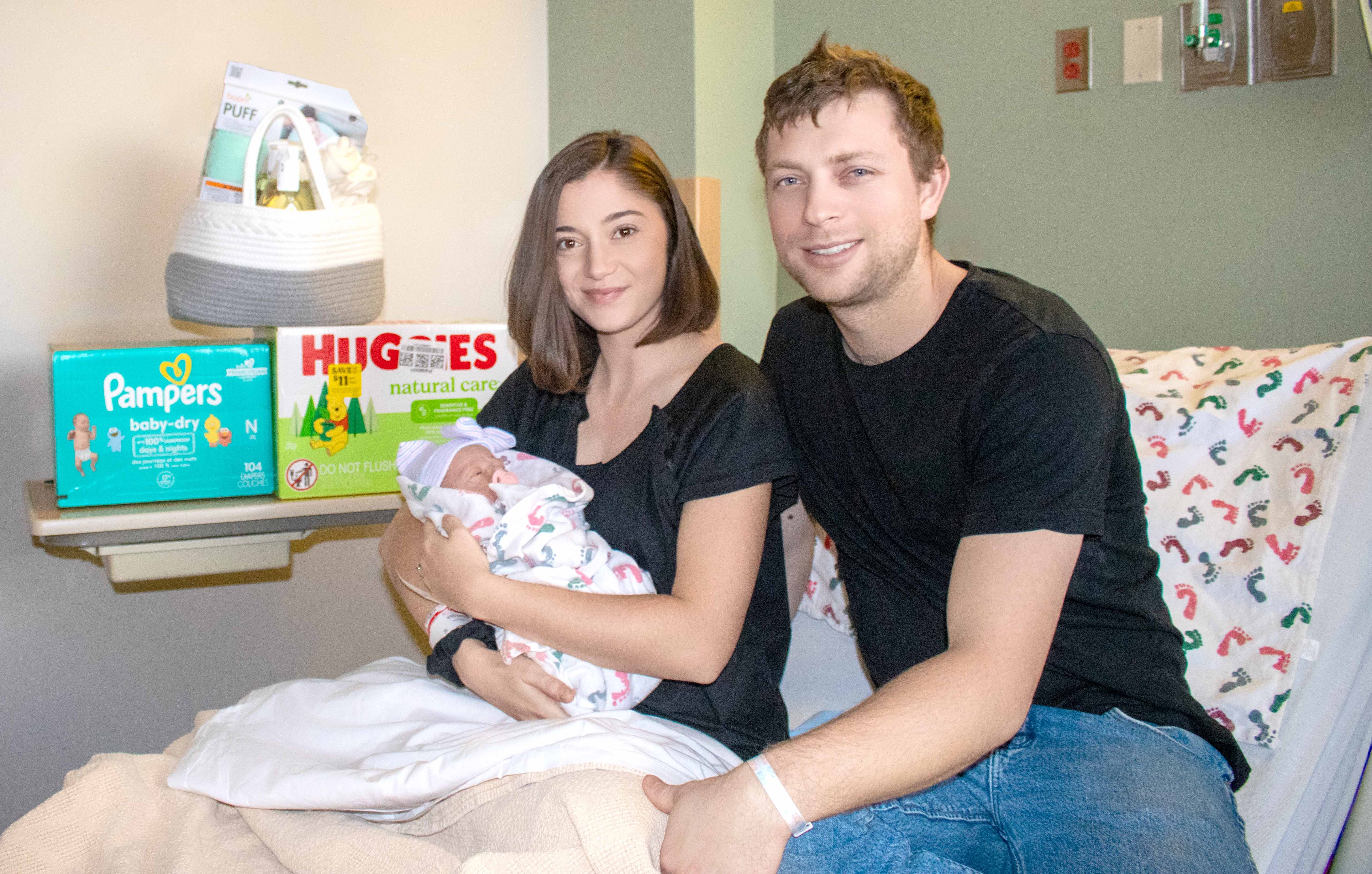 Cierra McCord holds her newborn baby Maeve while her husband, Westin sits next to her in the hospital bed 